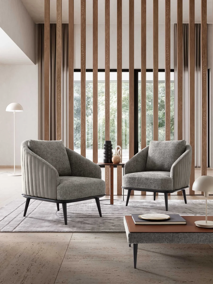 Lala — Modern, enveloping armchair with an outer shell featuring vertical quilting.