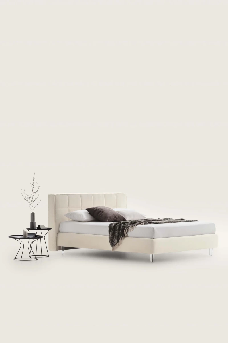 Gaucho — Bed with a squared headboard featuring a quilted square motif.