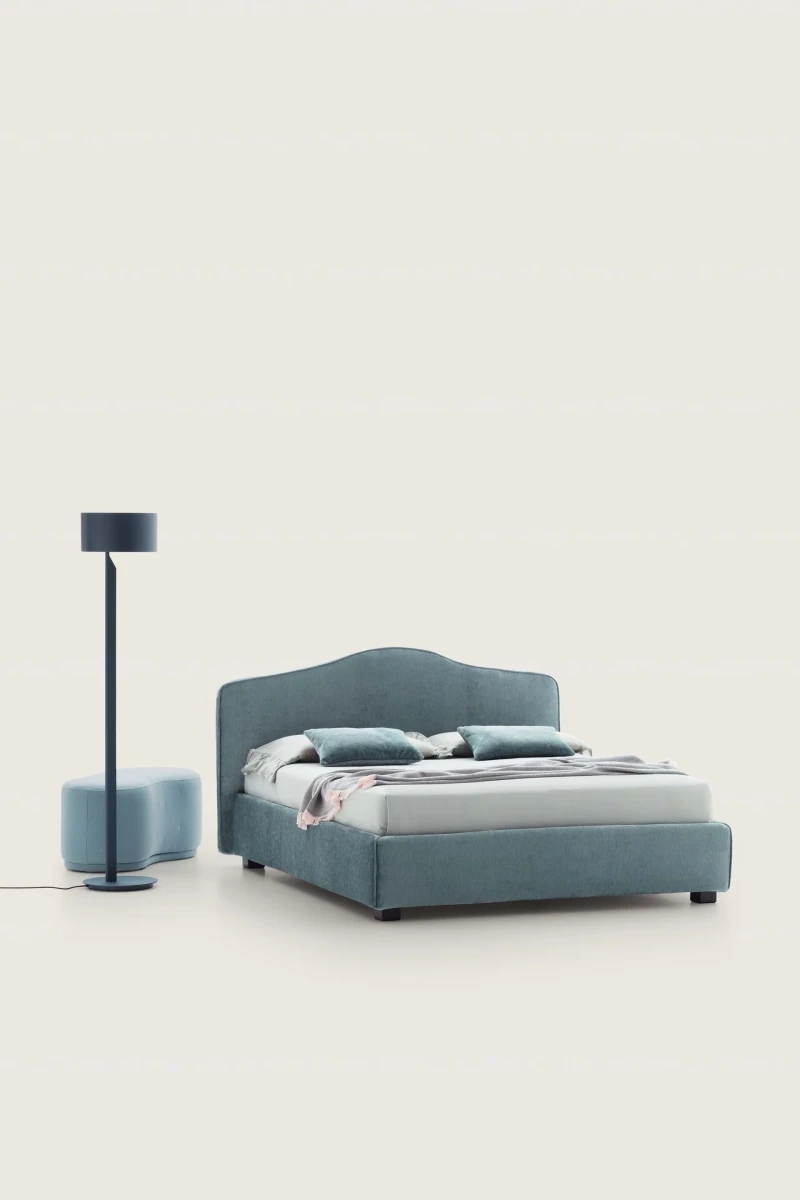 Rosa — Classic-style bed with a smooth, rounded upholstered headboard and decorative trim.