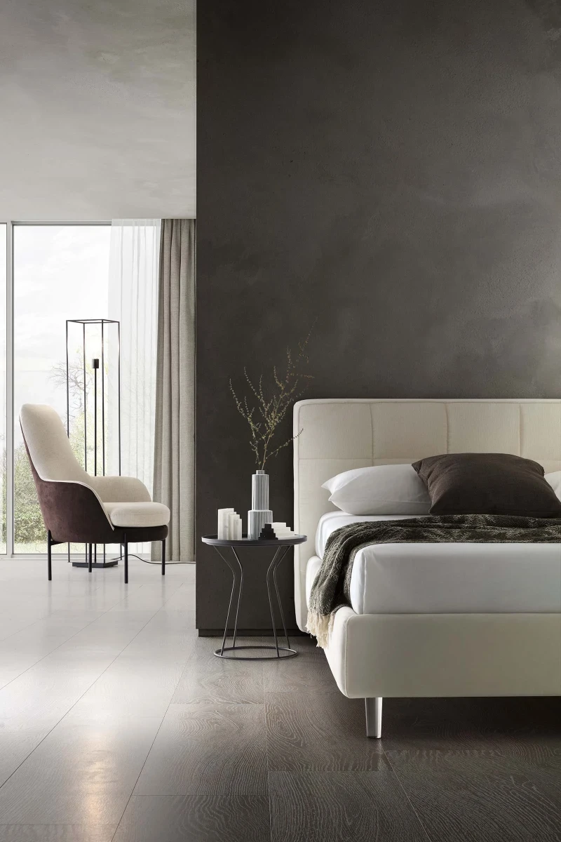 Gaucho — Bed with a squared headboard featuring a quilted square motif.