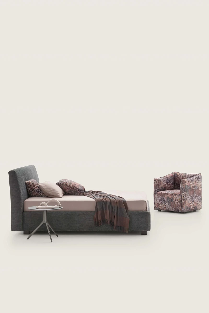 Break — Bed with a smooth, simple headboard and visible stitching.