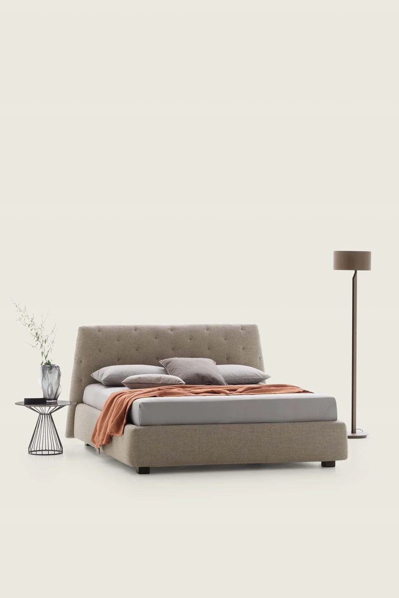Atrium — Bed with quilted headboard featuring contrasting "X" stitching.