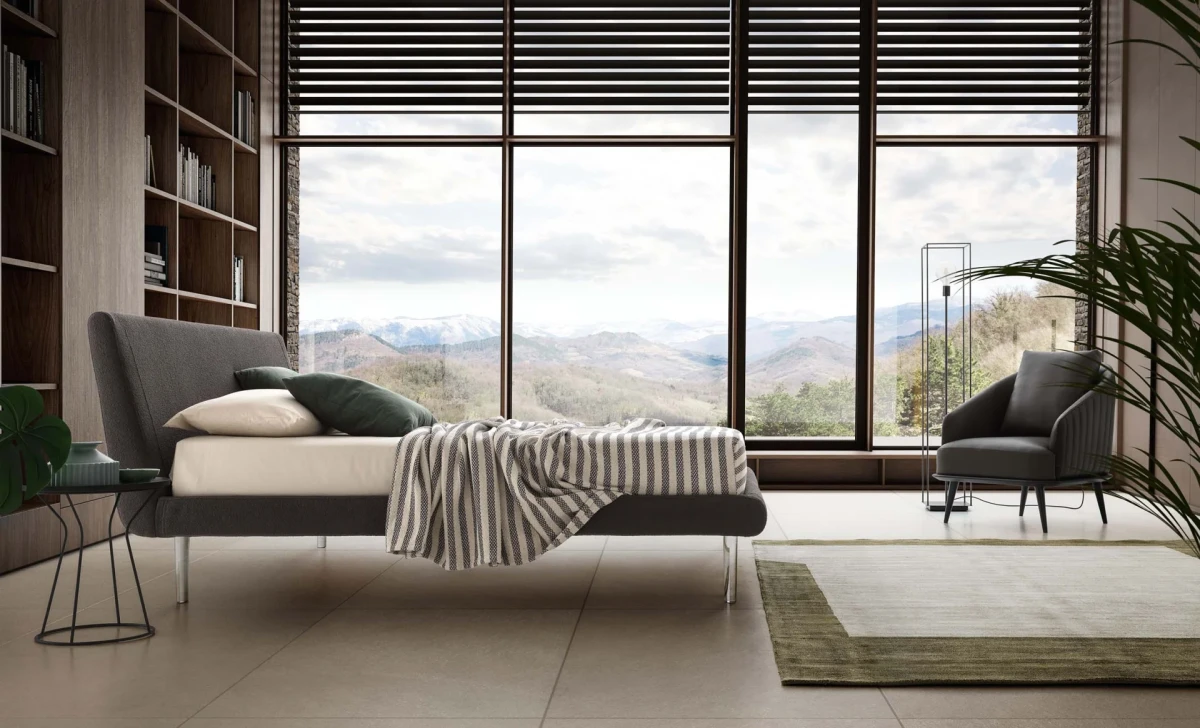 Metropolitan — Bed with a simple, slightly inclined upholstered headboard and subtle side stitching.