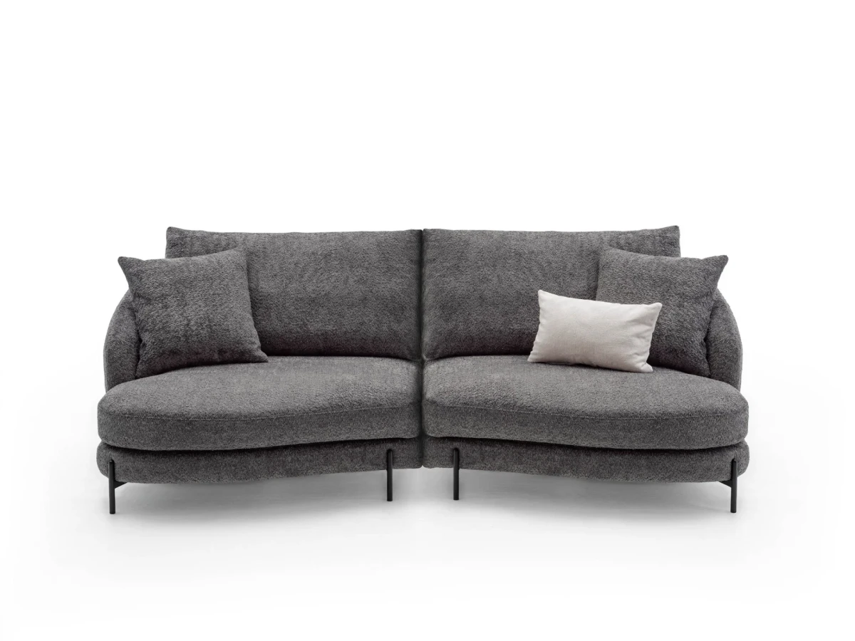 Jand — Sofa with organic shapes, high legs, round end modules, and shaped seats