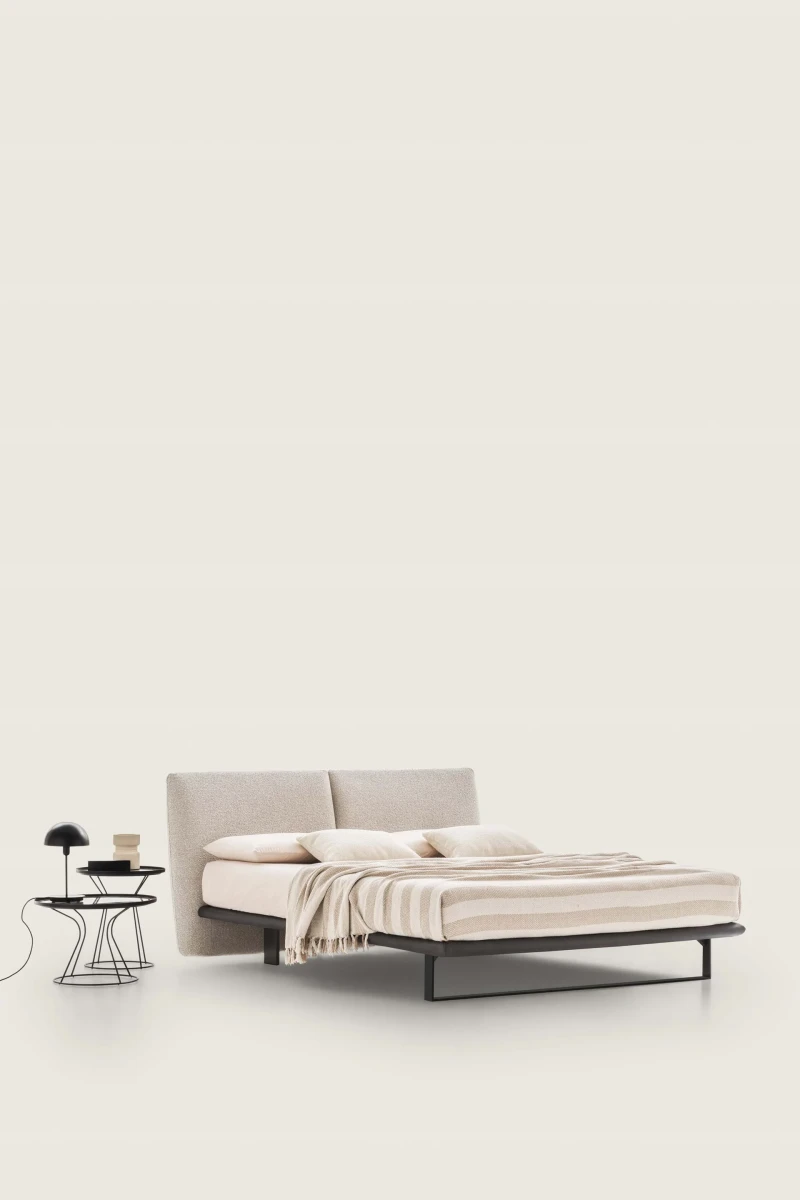 Monaco — Modern bed with a large headboard composed of upholstered cushions.
