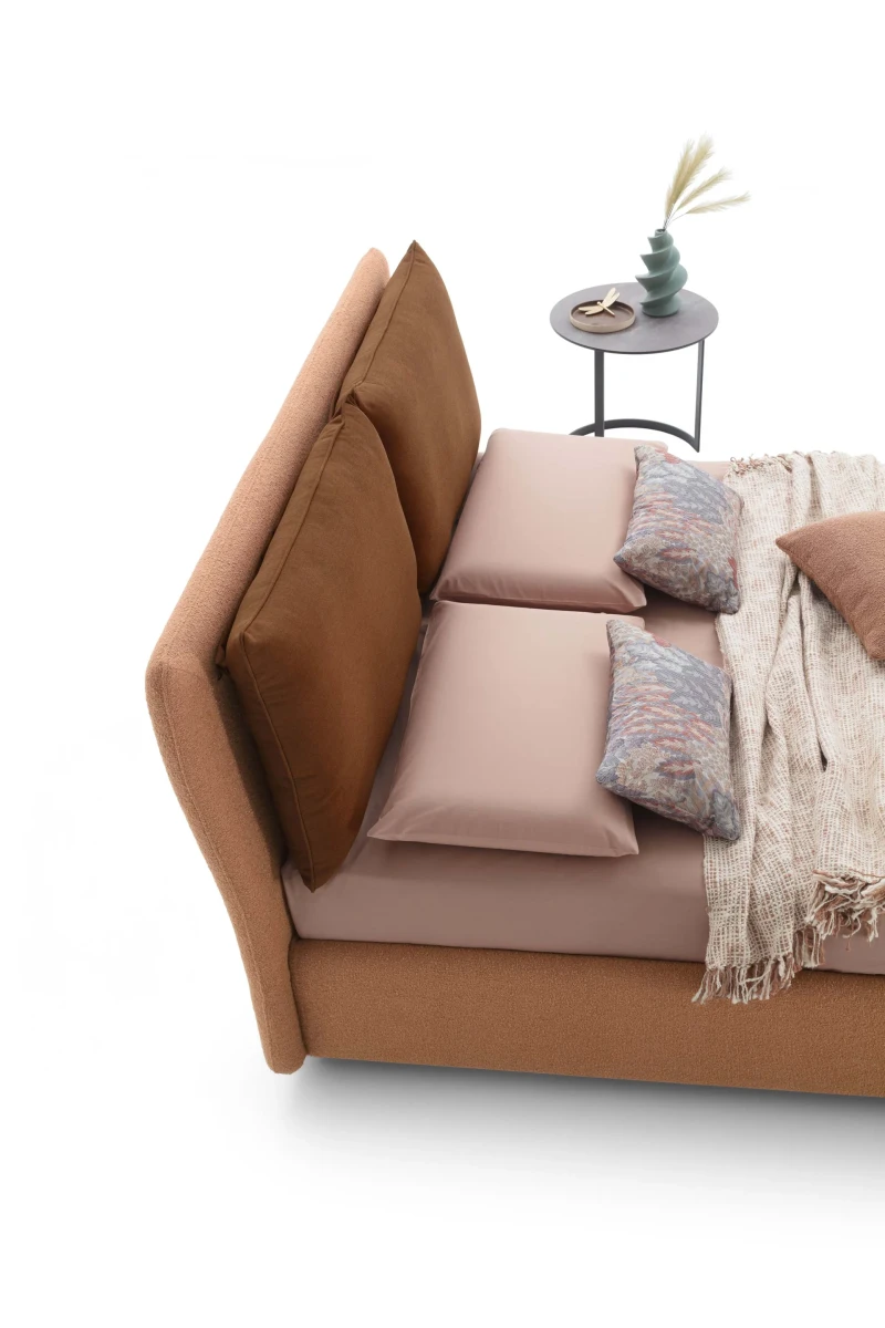 Fris — Bed with large cushions leaning against the headboard for optimal comfort.
