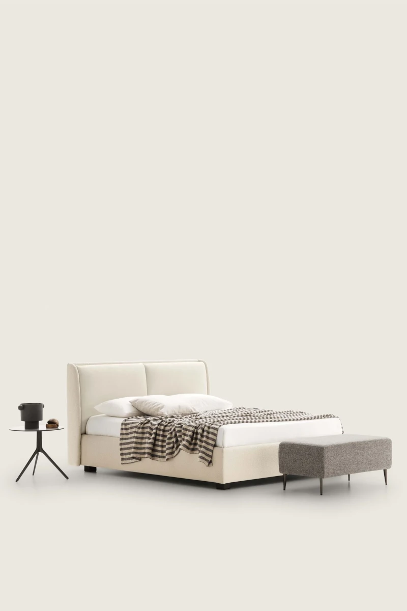 Windsor — Bed with a padded headboard composed of two delicately designed cushions.