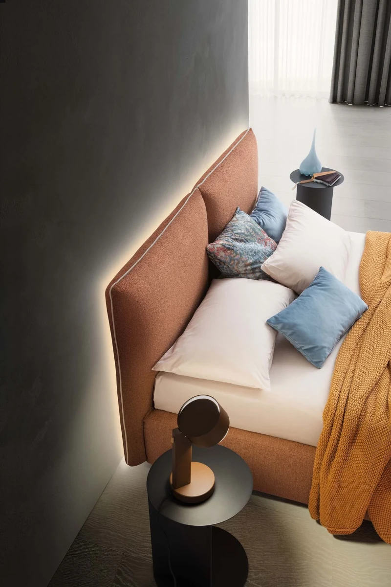 Allen — Comfortable bed with a headboard composed of large cushions with decorative piping.