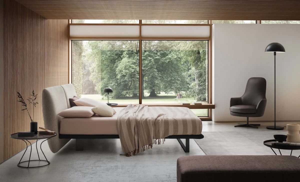 Monaco — Modern bed with a large headboard composed of upholstered cushions.