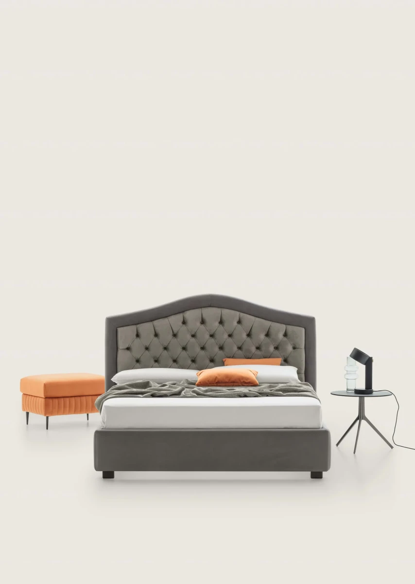 Dama — Classic-style bed with an arched tufted headboard.