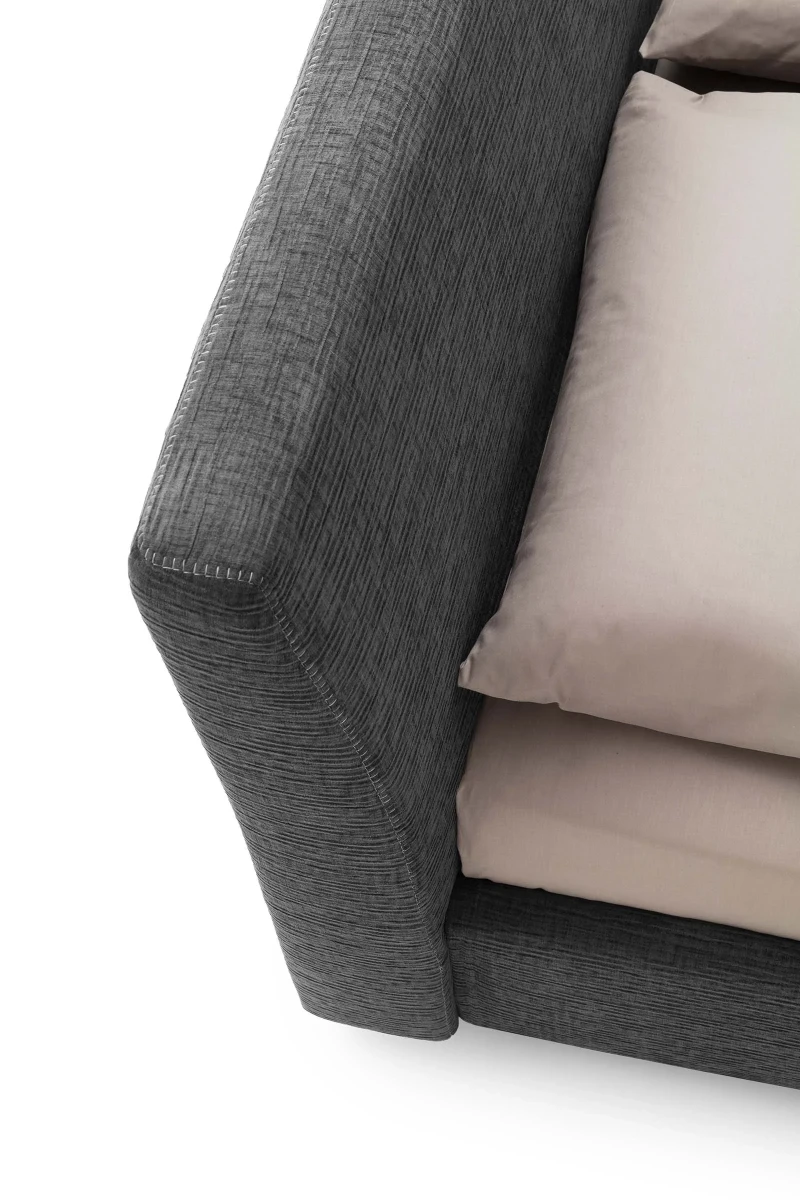 Break — Bed with a smooth, simple headboard and visible stitching.