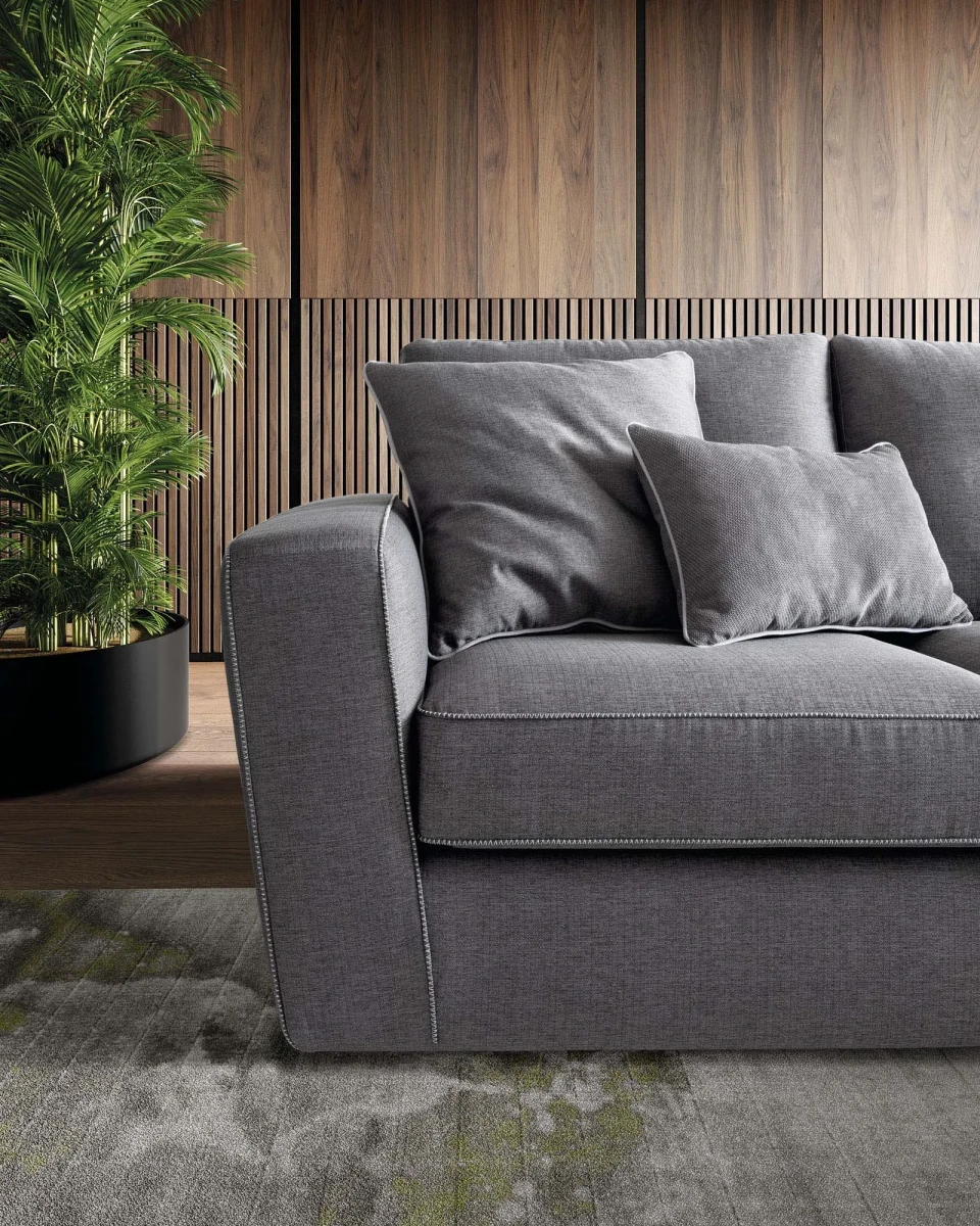 Magyster — Sofa with visible stitching and integrated side shelf.