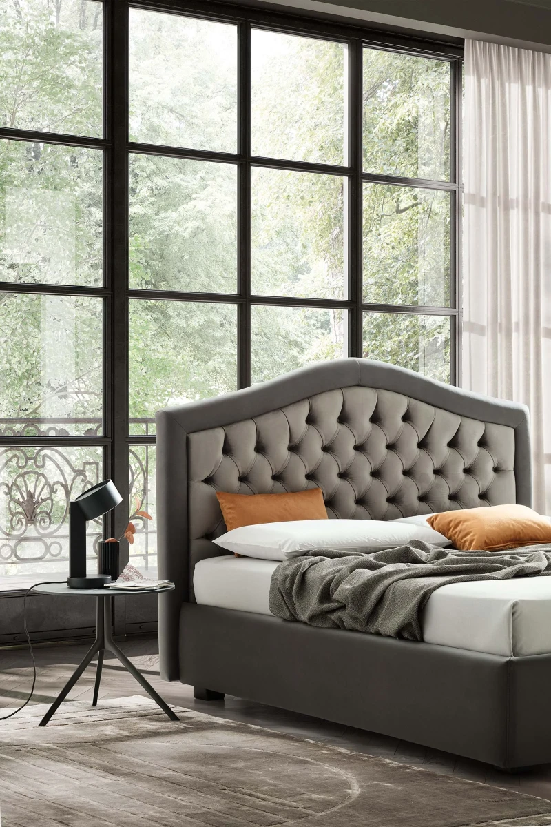 Dama — Classic-style bed with an arched tufted headboard.