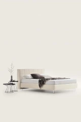 Gaucho — Bed with a squared headboard featuring a quilted square motif.