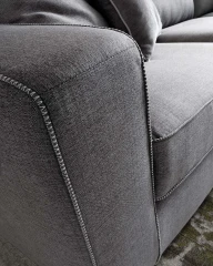Magyster — Sofa with visible stitching and integrated side shelf.