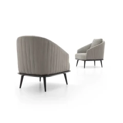 Lala — Modern, enveloping armchair with an outer shell featuring vertical quilting.