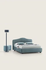 Rosa — Classic-style bed with a smooth, rounded upholstered headboard and decorative trim.