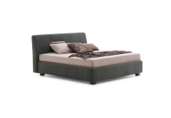Break — Bed with a smooth, simple headboard and visible stitching.