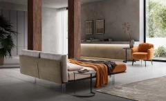 Essential — Bed with a headboard made of cushions resting on a semi-rigid panel.