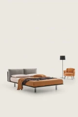 Essential — Bed with a headboard made of cushions resting on a semi-rigid panel.