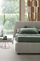 Calvin — Bed with a simple design featuring a softly rounded and smooth upholstered headboard.