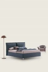 Catlin — Bed with a headboard composed of padded cushions with wide borders.