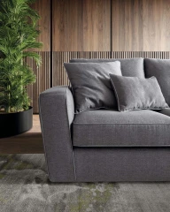 Magyster — Sofa with visible stitching and integrated side shelf.