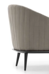 Lala — Modern, enveloping armchair with an outer shell featuring vertical quilting.