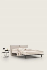 Monaco — Modern bed with a large headboard composed of upholstered cushions.
