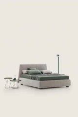Calvin — Bed with a simple design featuring a softly rounded and smooth upholstered headboard.