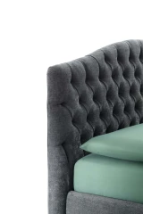 Renoir — Classic-style bed with a tall, curved headboard featuring full-width tufting.