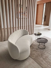 Moby Loveseat — Armless two-seater sofa with a sinuous shape and quilted backrest.