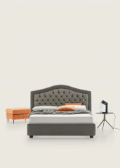 Dama — Classic-style bed with an arched tufted headboard.