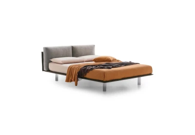 Essential — Bed with a headboard made of cushions resting on a semi-rigid panel.