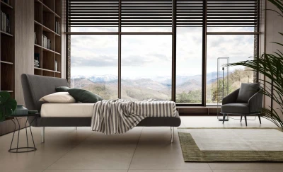 Metropolitan — Bed with a simple, slightly inclined upholstered headboard and subtle side stitching.