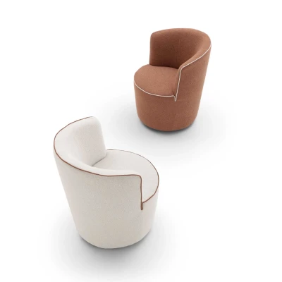 Dafne — Rounded and cozy armchair with barrell-like silhouette and contrasting edge details.