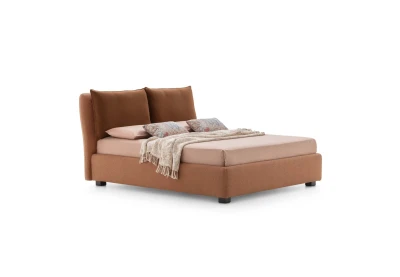 Fris — Bed with large cushions leaning against the headboard for optimal comfort.