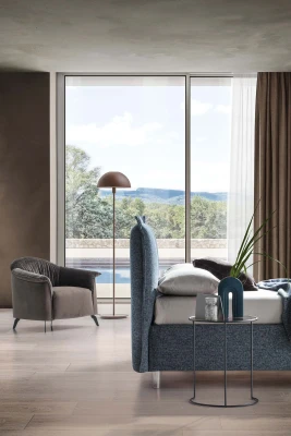 Catlin — Bed with a headboard composed of padded cushions with wide borders.