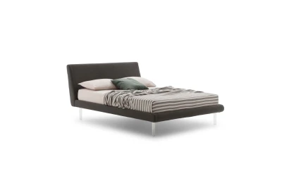Metropolitan — Bed with a simple, slightly inclined upholstered headboard and subtle side stitching.
