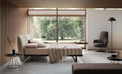 Monaco — Modern bed with a large headboard composed of upholstered cushions.