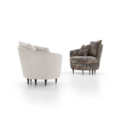 Privè — Elegant armchair with cushions resting on a slim, asymmetrical, and enveloping backrest.